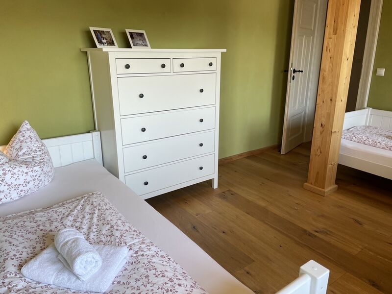 Schlafzimmer 2 mit zwei Einzelbetten und einer Kommode.